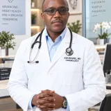 Dr. Job Mogire in a white cardiology coat, founder of House of Mastery